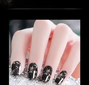 Détail de poudre à ongles en feuille d'argent sur vernis noir pour un effet miroir