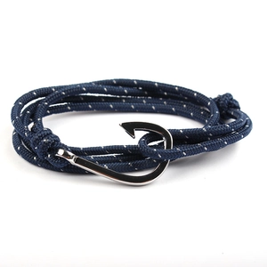 Navy blue woven nautical bracelet with polished silver anchor hook clasp on white background