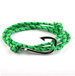 Detail of green and black paracord bracelet with silver-tone fish hook anchor clasp