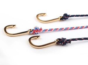 Detail of multi-layer woven bracelets with golden anchor clasps in navy and tricolor