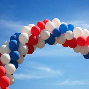 Detail view of red white and blue balloon arch assembly against a clear blue sky background