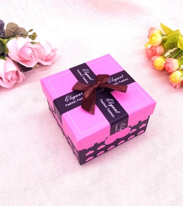 Vista dall'alto di scatola regalo rosa con cuori, nastro elegante e dettaglio fiocco