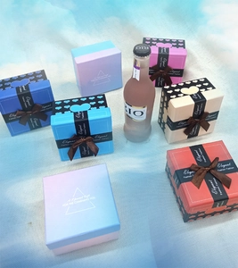 Piccole scatole regalo colorate con nastri eleganti e motivi a cuore su tessuto blu