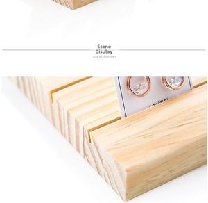 Detail of rose gold stud earrings with clear zircon on a wood display stand