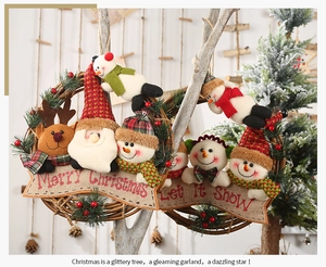 Close-up of rustic Christmas wreath with Santa and Snowman hanging on a wooden branch