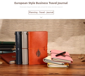 Detailed view of leather travel journals with elastic bands and vintage leaf pendants