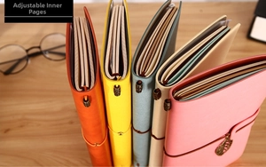 Detail of refillable leather journals with elastic closure and metal charms in various colors