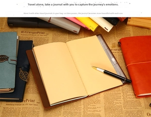 Close-up of vintage leather travel journals with elastic band and metal leaf charms