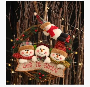 Close-up of rustic Christmas rattan wreath with cute snowmen and Let It Snow sign