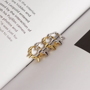 Close-up of S925 sterling silver ball and spike huggie earrings in gold and silver
