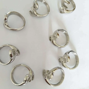 Detailed overhead view of multiple silver stainless steel skull rings in a circular layout