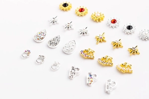 Vue macro de bijoux d'ongles en alliage avec perles et strass en finitions or et argent