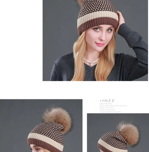 Detailed knit pattern of a winter coffee-colored beanie with a large fluffy fur pom-pom