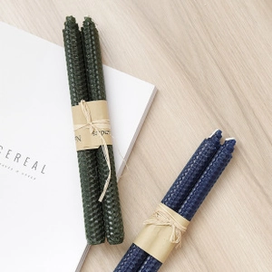 Close-up of beeswax candles with honeycomb texture and rustic hemp rope tie packaging