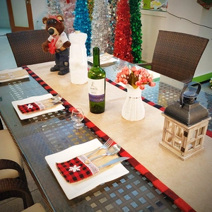 Détail d'un chemin de table en lin rustique avec bords à carreaux et pochette à couverts