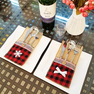 Détail de porte-couverts de Noël à carreaux rouges et toile de jute avec flocon sur assiettes