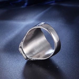Close-up of a silver titanium steel ring on blue silk showing smooth metal texture