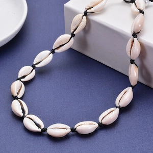 Collana di conchiglie e perle naturali con cordino nero intrecciato su blu scuro