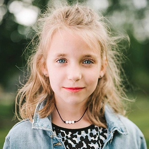 Handmade leather cord necklace featuring three white freshwater pearls on a model