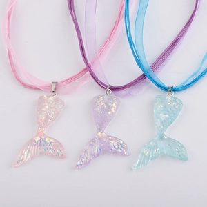 Detailed view of three shimmering resin mermaid tail necklaces in pink, purple and blue