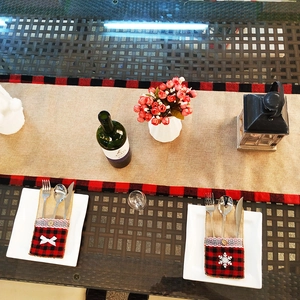 Détail de pochettes à couverts de Noël en toile de jute à carreaux rouges et noirs