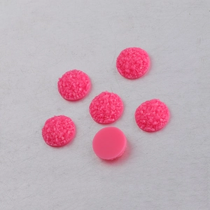 Detail of 10mm pink resin druzy cabochons showing textured surface and flat back