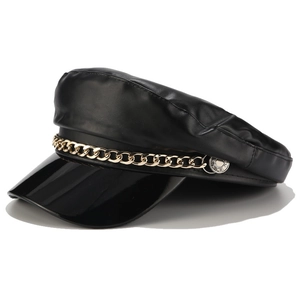 Side view of black faux leather newsboy cap with gold chain and silver side buckle