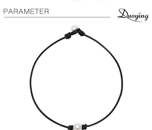 Detail of single natural freshwater pearl on black leather cord with knot closures