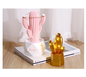 Dettaglio di statuette decorative a cactus in resina con calde luci a LED da tavolo