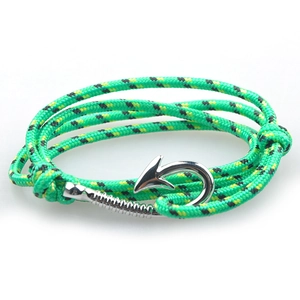 Macro view of green and black woven nautical bracelet with silver fish hook clasp