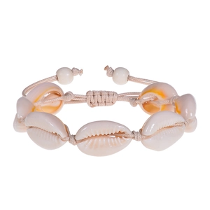 Close-up of handmade shell bracelet featuring beige sea shells on khaki braided cord