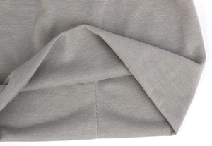 Close-up of fine grey knit fabric texture and high-quality hem stitching detail