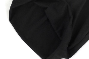 Detailed macro view showing the fine knitted texture and stitching of the black beanie