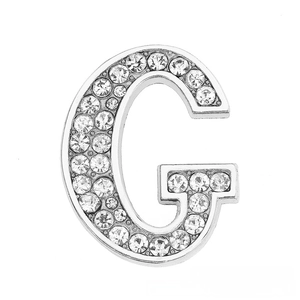 Close-up of a silver letter G charm encrusted with clear rhinestones for DIY jewelry