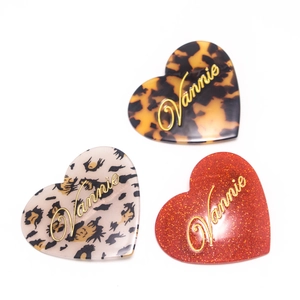 Trois barrettes cœur en acétate avec texte Vannie en léopard, beige et rouge pailleté
