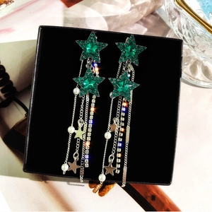 Dettaglio orecchini a stella verde con cristalli, nappe e perle in scatola regalo