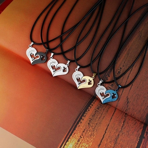 Detail of four heart pendant necklaces with 'I love you' engravings on wooden background