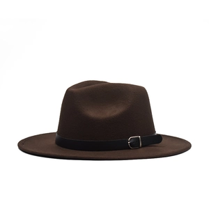 Detail of a brown wool fedora hat featuring a black leather band and gold metal buckle