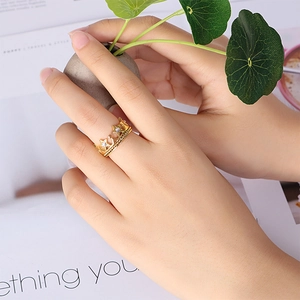 Elegant gold-plated crown and star ring with white zircon on a hand in lifestyle setting