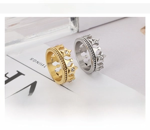 Detail showing crown-shaped star rings in gold and steel with inlaid white rhinestones