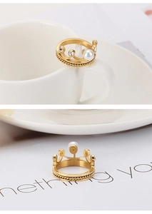 Détail de bague couronne avec perle et zircons sur anneau doré à texture torsadée
