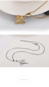 Vue macro du collier pendentif flèche de Cupidon avec détail cœur en doré et argenté
