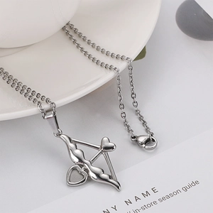 Collier flèche de Cupidon en acier inoxydable argenté sur un plateau blanc décoratif