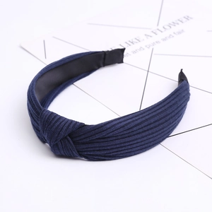 Close-up of navy blue ribbed fabric headband with a stylish knotted design