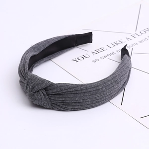 Detail of dark grey knitted fabric texture and twisted knot on wide cotton headband