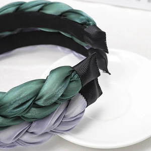 Detailed view of woven satin headbands in dark green and violet grey textures