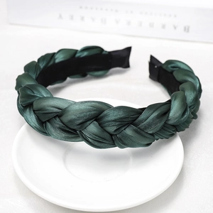 Detail of dark green braided headband with satin finish on elegant white background