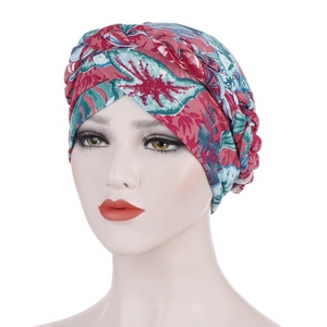 Close-up of the braided twist detail on the floral print turban cap with vibrant patterns
