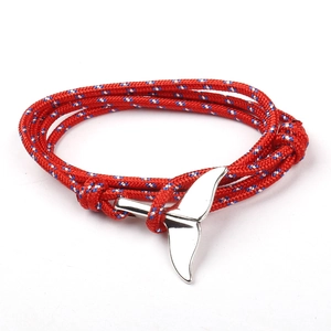 Red braided nautical bracelet with silver whale tail anchor clasp on white background
