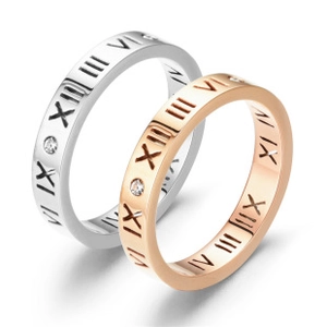 Detailed macro of silver and rose gold steel rings with roman numerals and diamonds